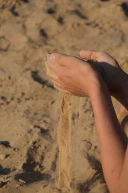 El çırpması altın kum parmaklarından dökülüyor, yazı için yer var.