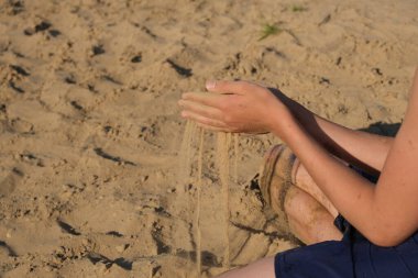 El çırpması altın kum parmaklarından dökülüyor, yazı için yer var.