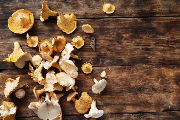 Chanterelle mantarları ahşap bir masaya saçılmış.