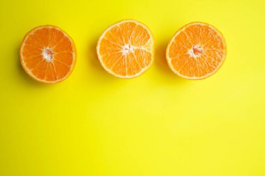 Turuncu hala hayat. Sarı arka planda taze portakal dilimlerinin meyve deseni. Üst Manzara. Uzayı kopyala Pop sanat tasarımı, yaratıcı yaz konsepti. Minimum düzlükte turunçgilin yarısı yatıyordu. Pankart