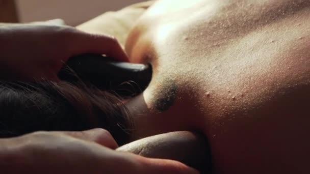 Primer masaje de cuello con piedras calientes en el salón de spa — Vídeo de stock