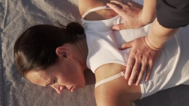 Närbild ung kvinna gör thai yoga massage på ett trägolv vid soluppgången — Stockvideo