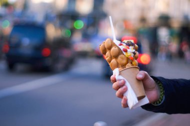 El ile meyve, çikolata ve şekerleme, kopya alanı ile kabarcık gözleme tutarak.