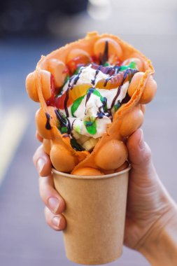 El ile meyve, çikolata ve şekerleme, kopya alanı ile kabarcık gözleme tutarak.