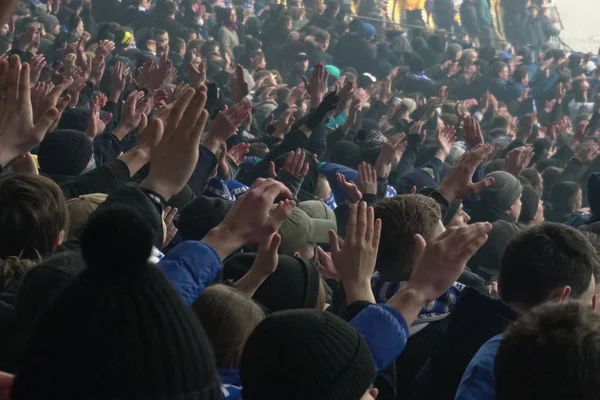 Μεγάλο πλήθος των οπαδών του ποδοσφαίρου παλαμάκια τα χέρια, υποστήριξη της ομάδας τους. Πλήθος των φιλάθλων που παρακολουθούν το παιχνίδι στο γήπεδο, αργή κίνηση — Φωτογραφία Αρχείου