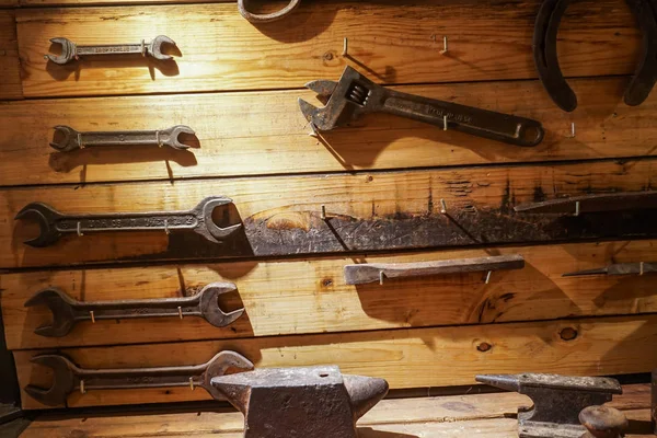 A collection of vintage tools displayed on a background of grey barnboard. — Stock Photo, Image