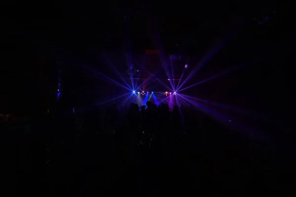 Skara människor dansar under disco laserljus — Stockfoto