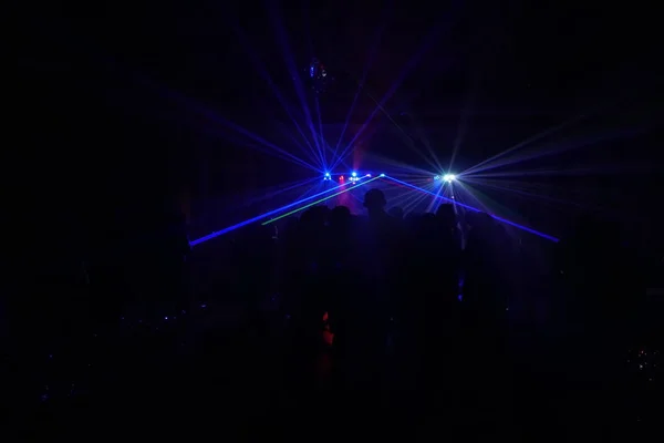 Kerumunan orang menari di bawah disko sinar laser — Stok Foto
