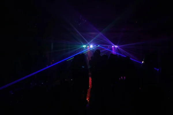 Crowd of people dancing under disco laser light — Stock Photo, Image
