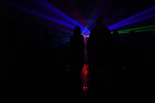 Crowd of people dancing under disco laser light — Stock Photo, Image