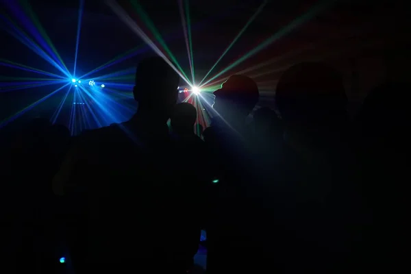 Multitud de personas bailando bajo la luz láser disco —  Fotos de Stock
