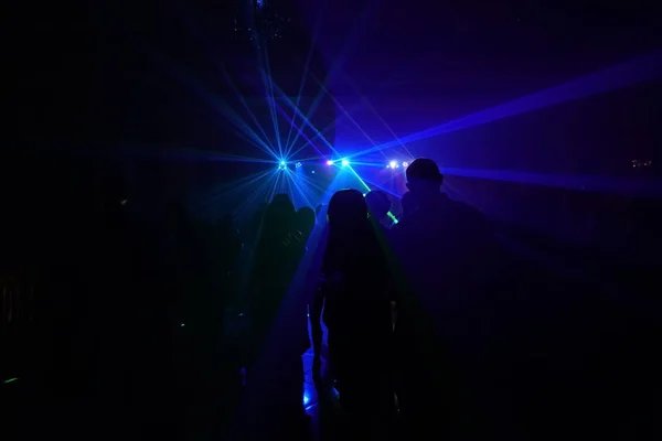 Foule de gens dansant sous la lumière laser disco — Photo