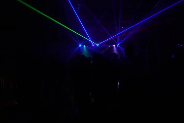 Skara människor dansar under disco laserljus — Stockfoto