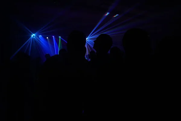 Multidão de pessoas dançando sob luz laser disco — Fotografia de Stock