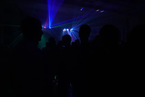 Menigte van mensen dansen onder disco laserlicht — Stockfoto