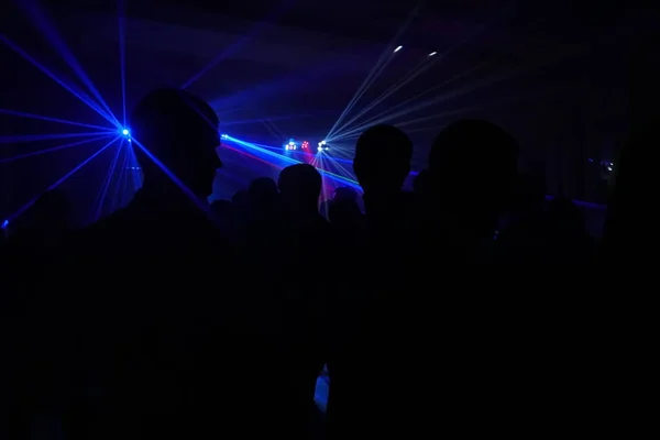 Dav lidí tančí pod disco laserové světlo — Stock fotografie