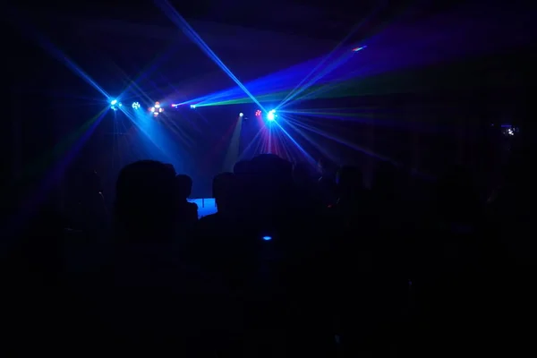 Crowd of people dancing under disco laser light — Stock Photo, Image