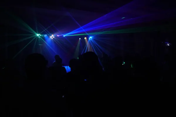 Crowd of people dancing under disco laser light — Stock Photo, Image
