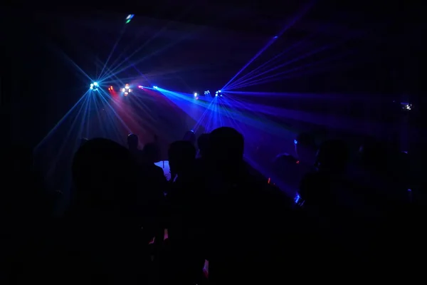 Натовп людей, що танцюють під диско-лазерним світлом — стокове фото