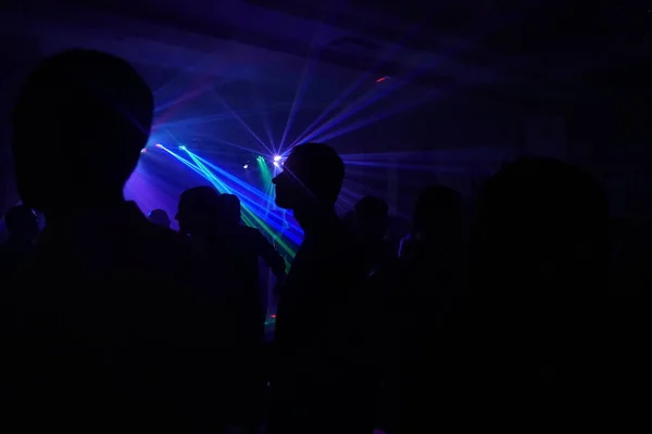 Foule de gens dansant sous la lumière laser disco — Photo