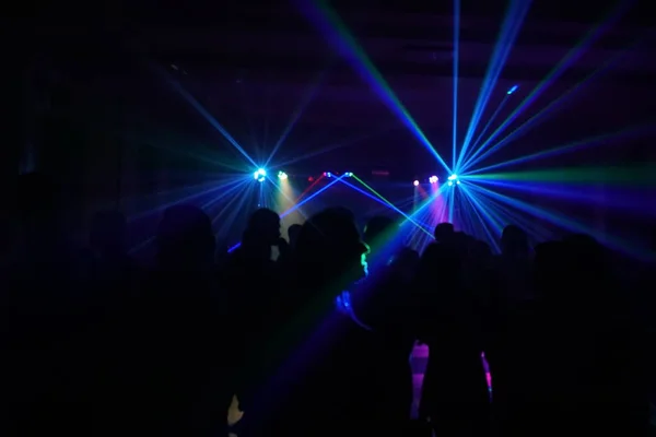 Menschenmenge tanzt unter Disco-Laserlicht — Stockfoto