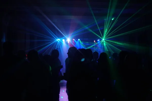 Foule de gens dansant sous la lumière laser disco — Photo