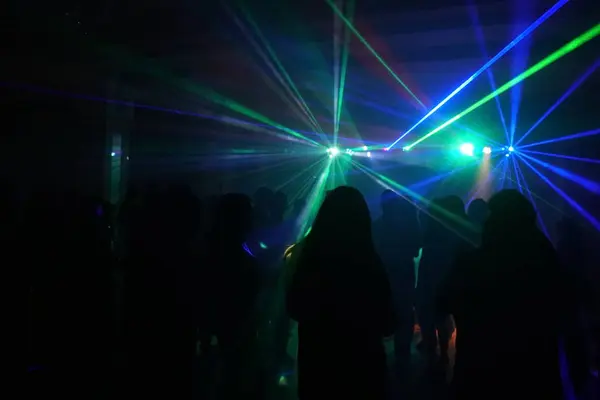 Foule de gens dansant sous la lumière laser disco — Photo