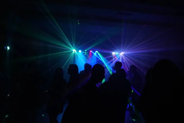 Foule de gens dansant sous la lumière laser disco — Photo