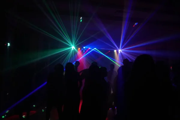 Foule de gens dansant sous la lumière laser disco — Photo