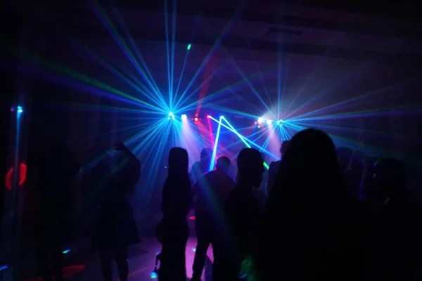 Foule de gens dansant sous la lumière laser disco — Photo