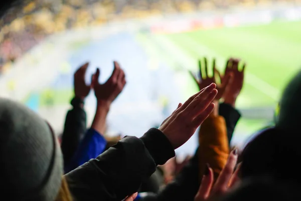 Fãs de futebol levantando as mãos, cantando, apoiando a equipe nacional no estádio — Fotografia de Stock