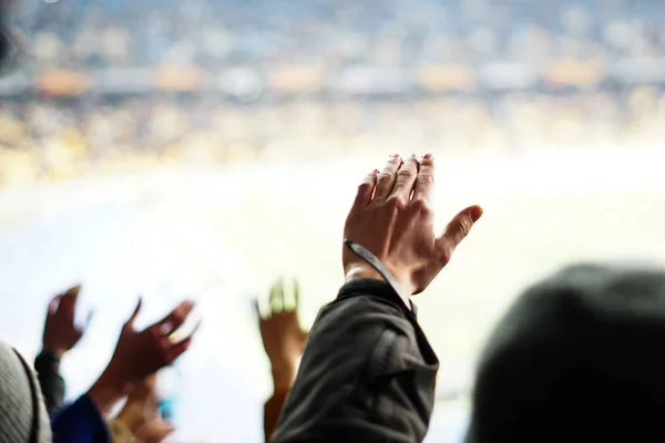 Футбольні фанати піднімають руки, співають, підтримують національну збірну на стадіоні — стокове фото