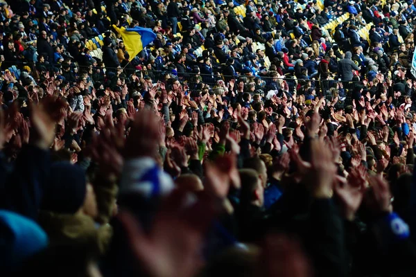 Fãs de futebol levantando as mãos, cantando, apoiando a equipe nacional no estádio — Fotografia de Stock