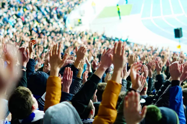 Vintage style photo of a crowd, happy people enjoying rock concert, raised up hands and clapping of pleasure, active night life concept