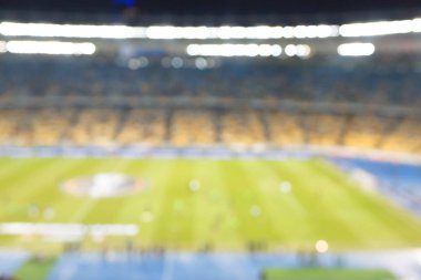 Alacakaranlık vakti, soyut arka plan kullanımı için futbol stadyumunun bulanık görüntüsü.