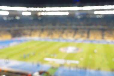 Alacakaranlık vakti, soyut arka plan kullanımı için futbol stadyumunun bulanık görüntüsü.