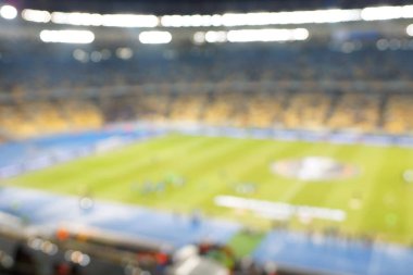 Alacakaranlık vakti, soyut arka plan kullanımı için futbol stadyumunun bulanık görüntüsü.