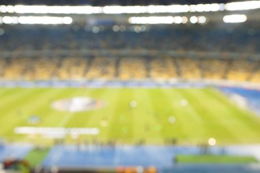 Alacakaranlık vakti, soyut arka plan kullanımı için futbol stadyumunun bulanık görüntüsü.