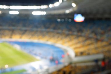 Alacakaranlık vakti, soyut arka plan kullanımı için futbol stadyumunun bulanık görüntüsü.