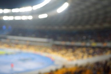 Alacakaranlık vakti, soyut arka plan kullanımı için futbol stadyumunun bulanık görüntüsü.