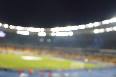 Alacakaranlık vakti, soyut arka plan kullanımı için futbol stadyumunun bulanık görüntüsü.