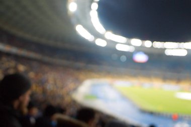 Alacakaranlık vakti, soyut arka plan kullanımı için futbol stadyumunun bulanık görüntüsü.