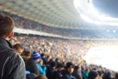 Alacakaranlık vakti, soyut arka plan kullanımı için futbol stadyumunun bulanık görüntüsü.