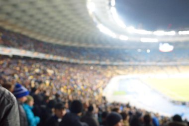 Alacakaranlık vakti, soyut arka plan kullanımı için futbol stadyumunun bulanık görüntüsü.