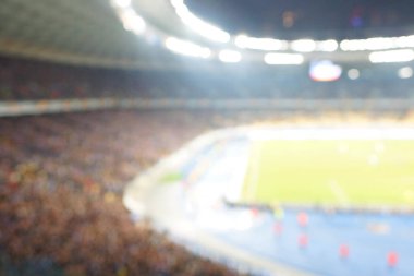 Alacakaranlık vakti, soyut arka plan kullanımı için futbol stadyumunun bulanık görüntüsü.