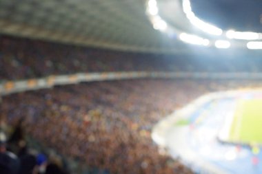 Alacakaranlık vakti, soyut arka plan kullanımı için futbol stadyumunun bulanık görüntüsü.