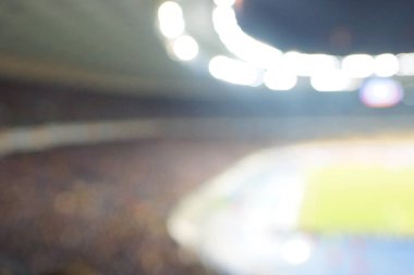 Alacakaranlık vakti, soyut arka plan kullanımı için futbol stadyumunun bulanık görüntüsü.