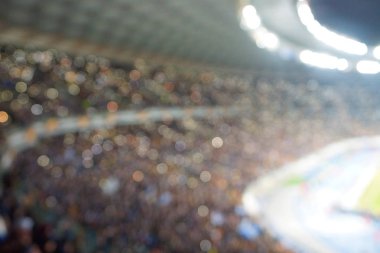 Alacakaranlık vakti, soyut arka plan kullanımı için futbol stadyumunun bulanık görüntüsü.