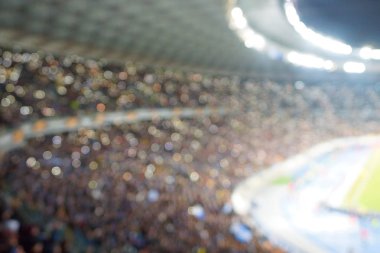 Alacakaranlık vakti, soyut arka plan kullanımı için futbol stadyumunun bulanık görüntüsü.