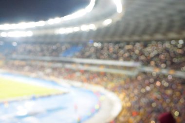 Alacakaranlık vakti, soyut arka plan kullanımı için futbol stadyumunun bulanık görüntüsü.
